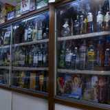 A destra una serie di vecchi scaffali ospitano i liquori...